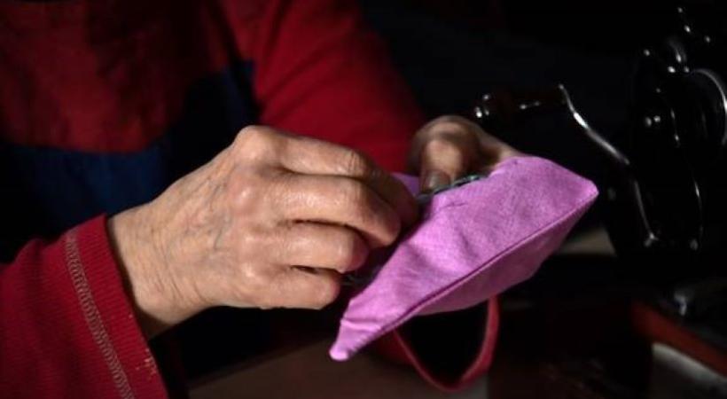 Hands darning a cushion